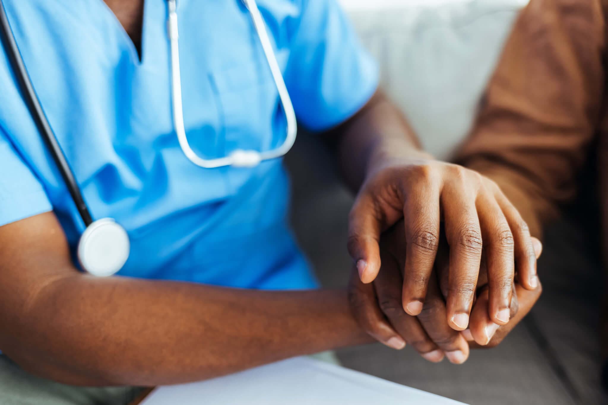 Close up picture of nurse holding patients hands