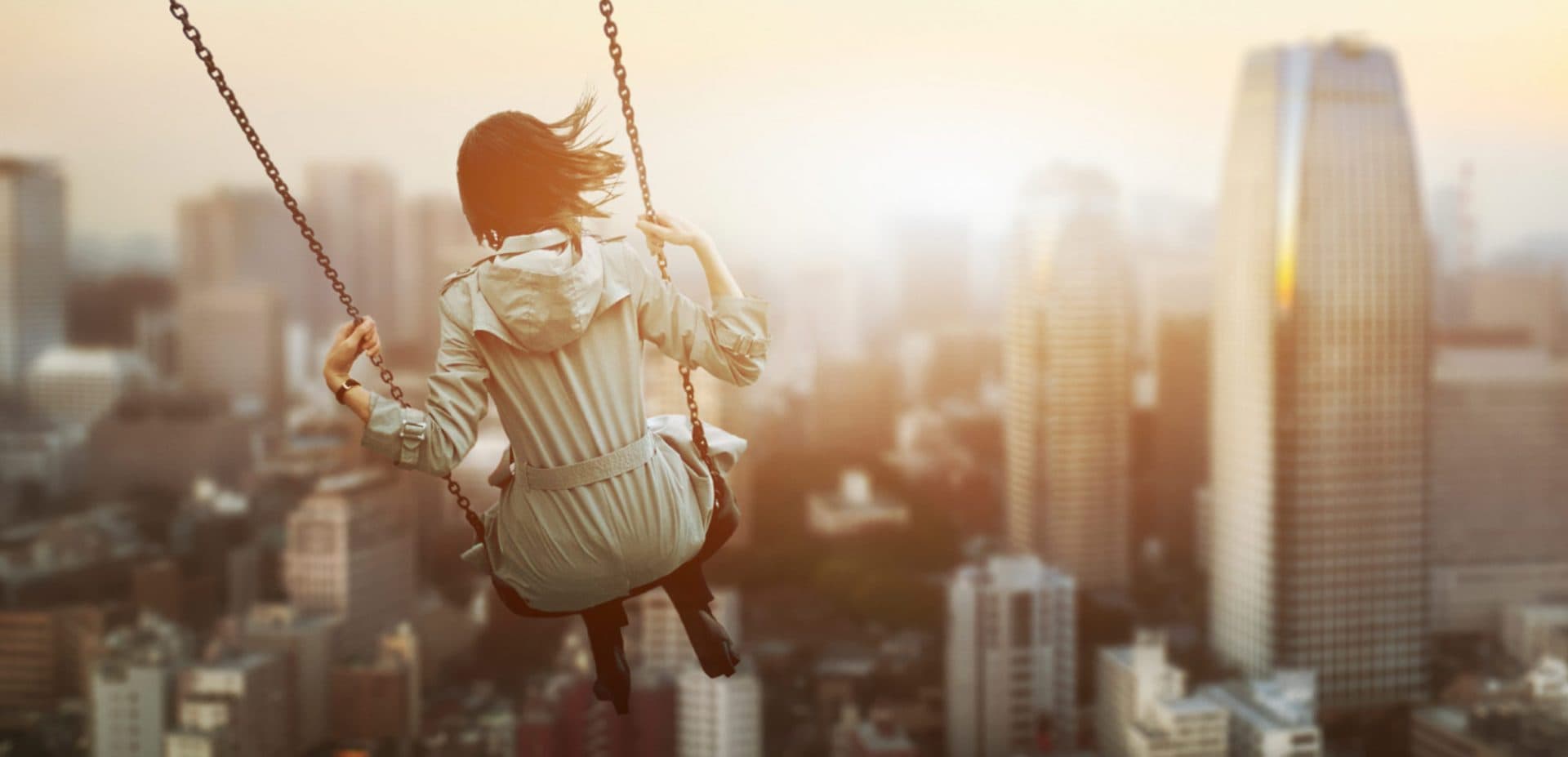 Person on swing above buildings