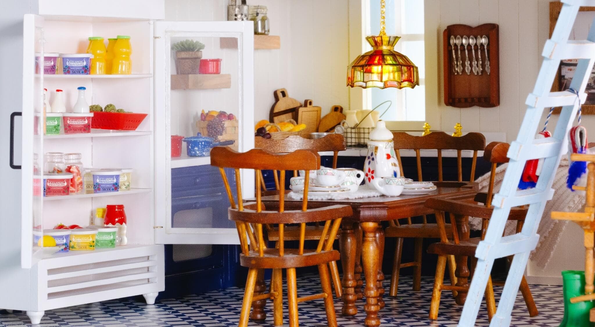 Image is a closeup of the decorated kitchen of the elf house, with a ladder going up to the right.