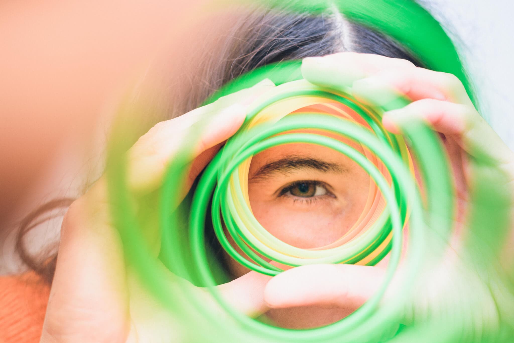 Girl looking through a spiral of colors.