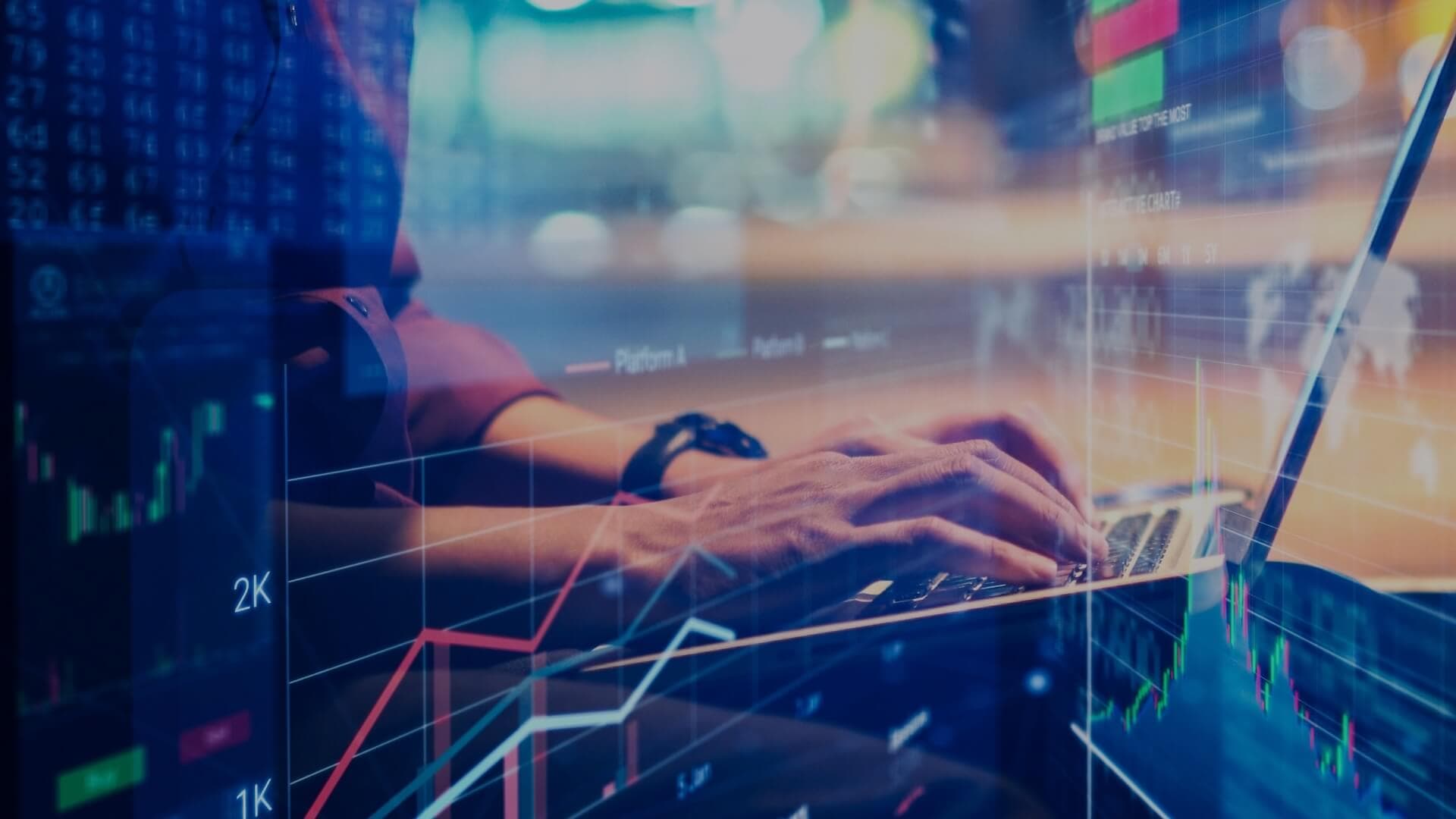 Image of a person typing on a laptop with visuals of computer generated charts visible on top