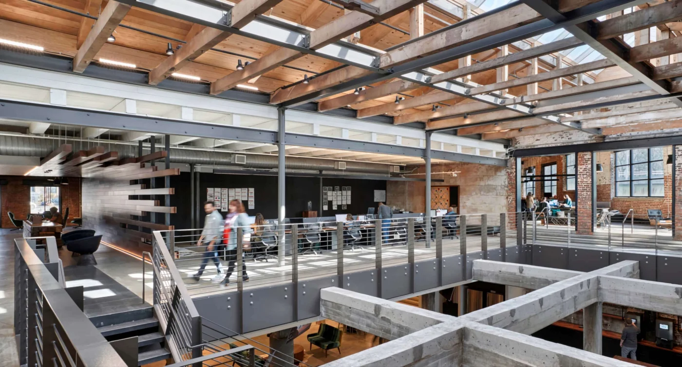 Open-plan office in Weber Shandwick Atlanta’s West Midtown space, featuring industrial architecture and collaborative work areas