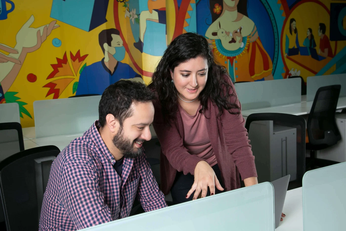Team members collaborating at computer in Weber Shandwick Mexico City office, reflecting creative and inclusive workplace culture