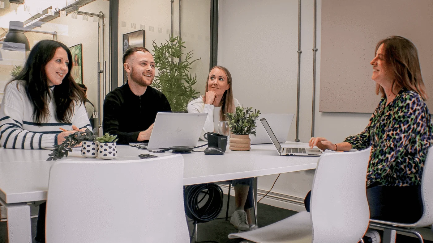 Weber Shandwick Manchester team collaborating in office meeting with laptops, reflecting UK-based global communications expertise