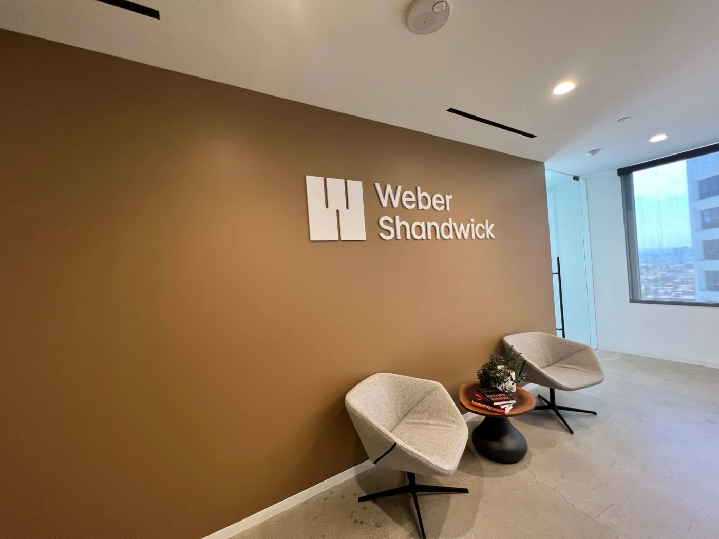 Weber Shandwick Los Angeles office interior with brand signage and seating area, showcasing modern workspace environment in California