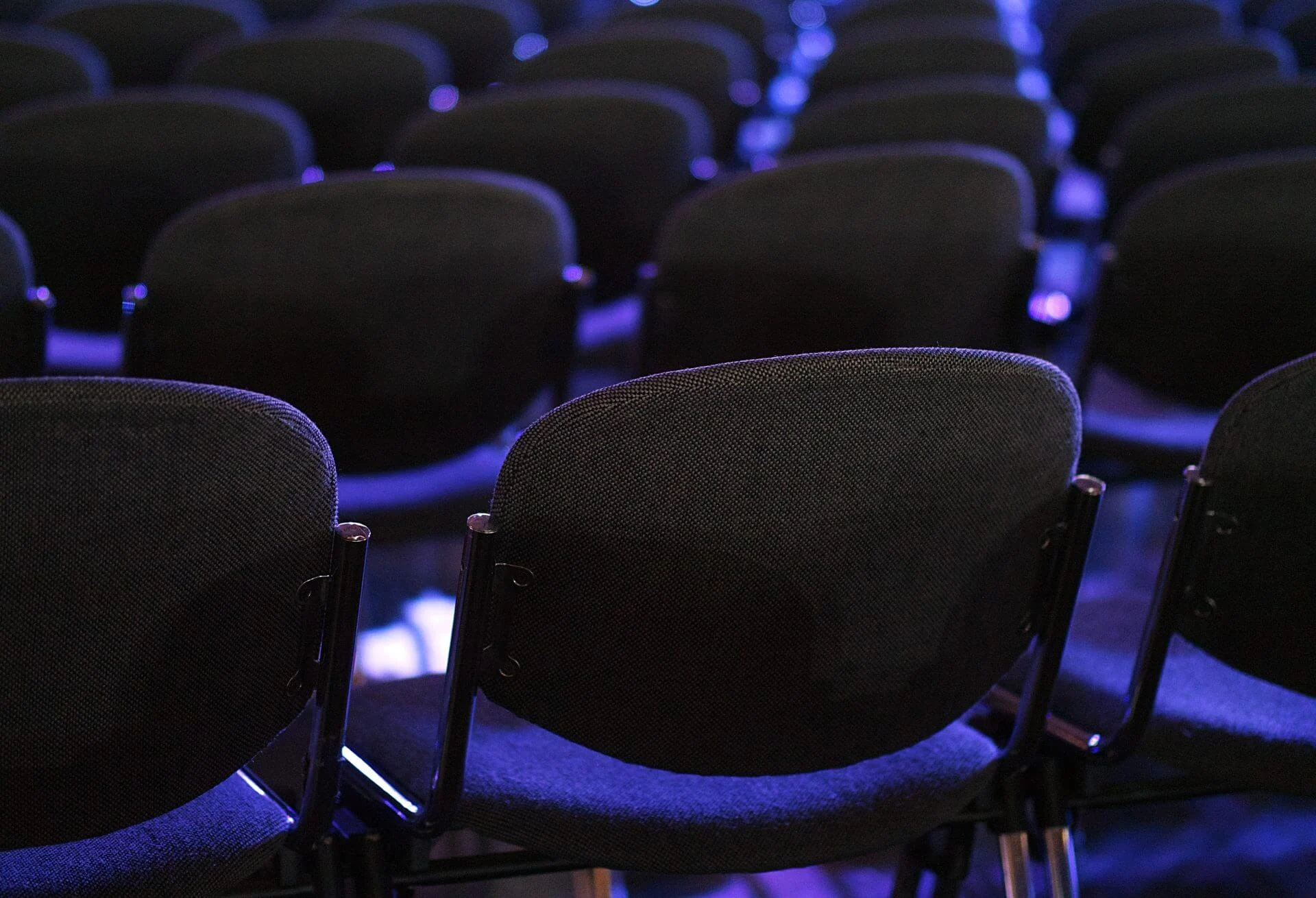 Conference auditorium seating, representing executive events and speaking engagements for global business leaders and industry conferences