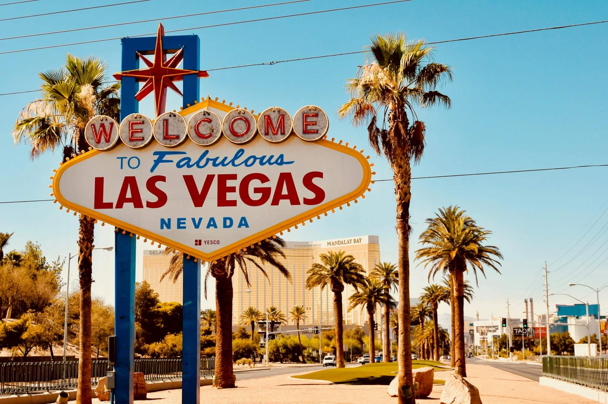 Welcome to Fabulous Las Vegas sign with palm trees and skyline, setting the stage for a major entertainment and marketing event atmosphere